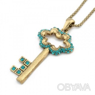 Ожерелье золотистого цвета с подвеской в форме ключика с мерцающими голубыми стр. . фото 1